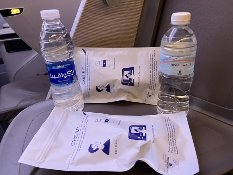 a group of water bottles and white bags on a seat