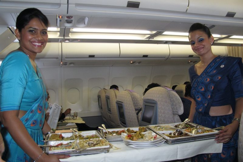 a couple of women standing in an airplane