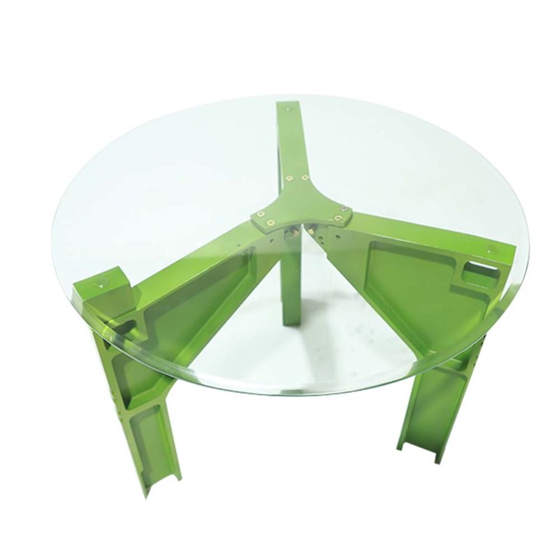 a green metal table with a glass top