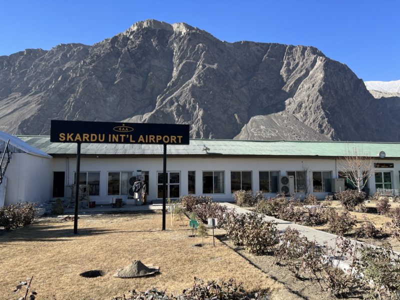 a building with a sign in front of a mountain