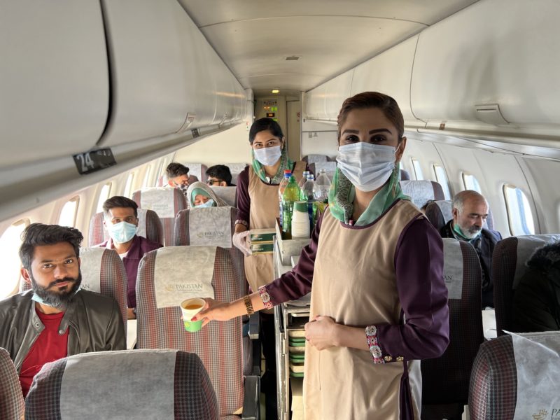 a group of people wearing face masks on an airplane