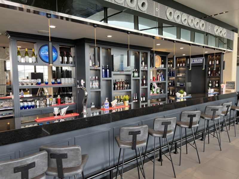 a bar with a row of stools and bottles