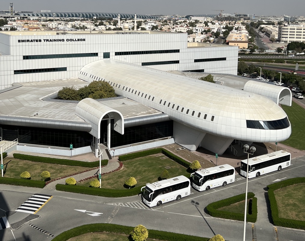 a large white building with many buses parked outside