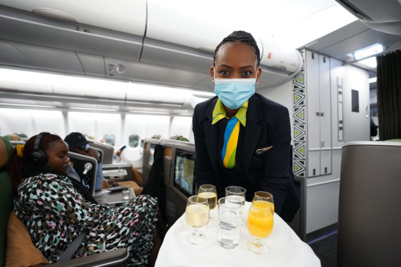 a woman wearing a mask and holding a tray of drinks