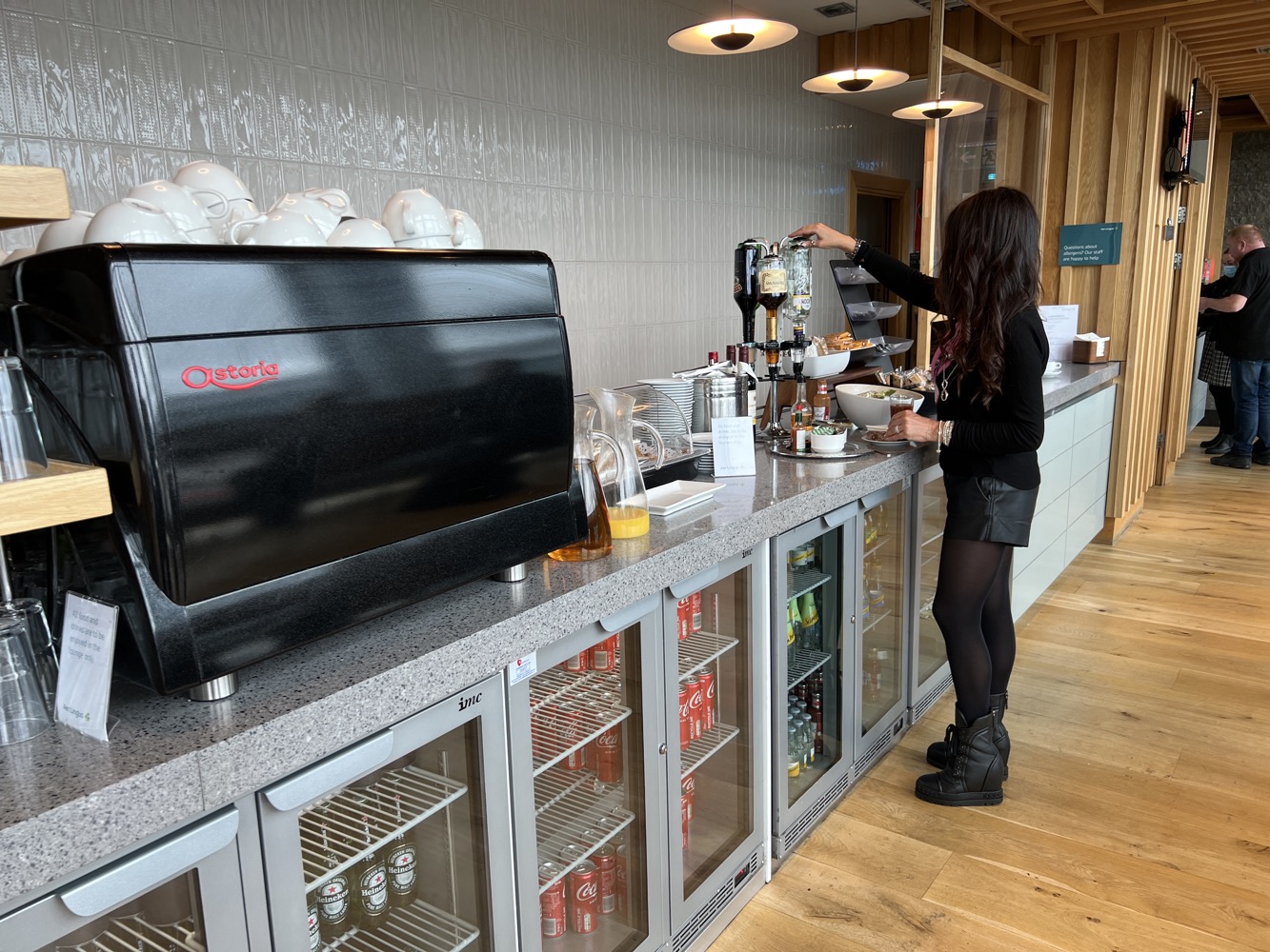 a woman standing at a counter with a coffee machine