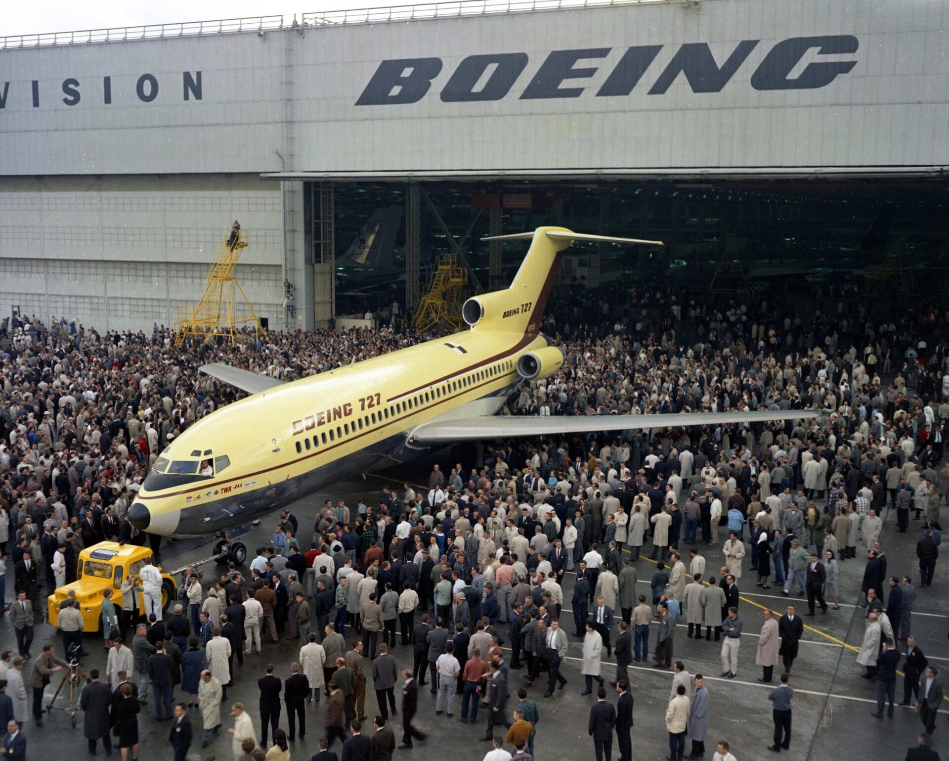 a large group of people standing around an airplane