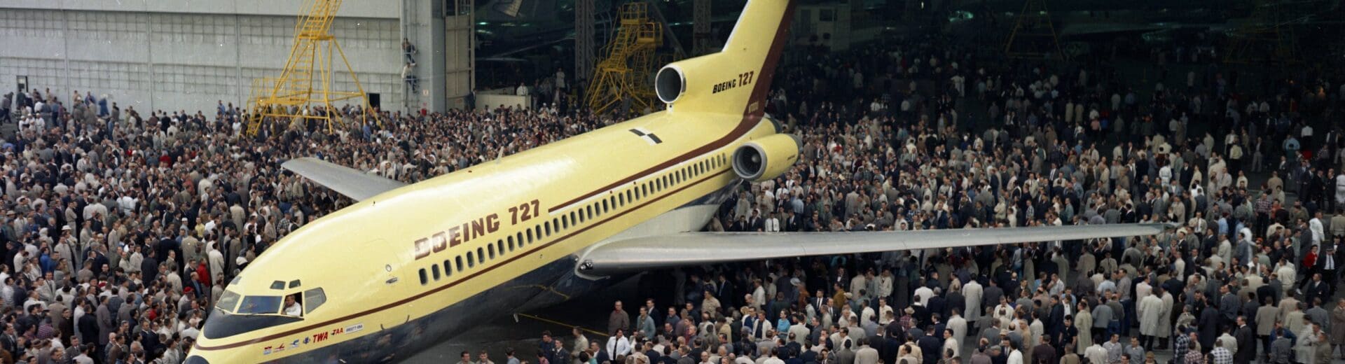 a large group of people standing around an airplane