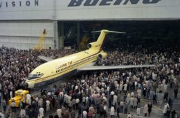 a large group of people standing around an airplane