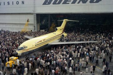 a large group of people standing around an airplane