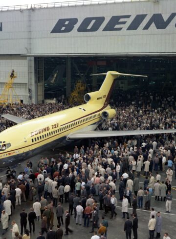 a large group of people standing around an airplane