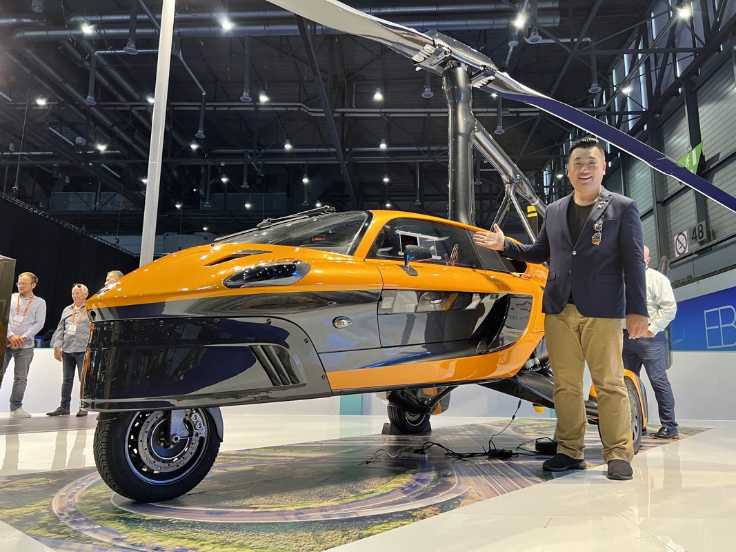 a man standing next to a small yellow and black vehicle