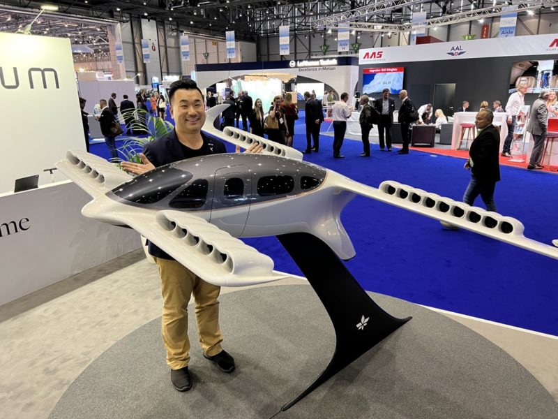 a man standing next to a model of a plane