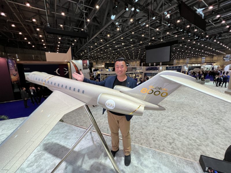 a man standing next to a model airplane