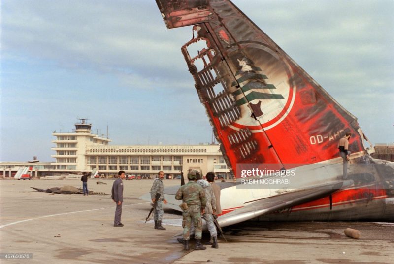 The Lebanese Army soldiers surround the burned stabilizer of the Middle East Airlines (MEA) aircraft which was hit 08 January 1987 by a rockets during a heavy shelling on the Beirut airport. (Photo credit: RABIH MOGHRABI/AFP via Getty Images)