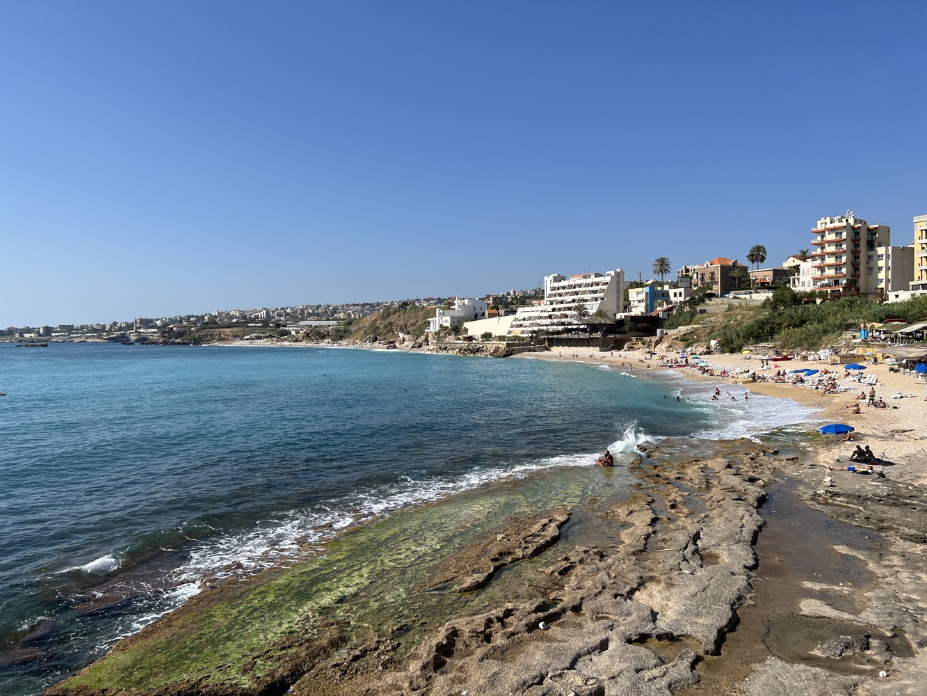 a beach with people and buildings