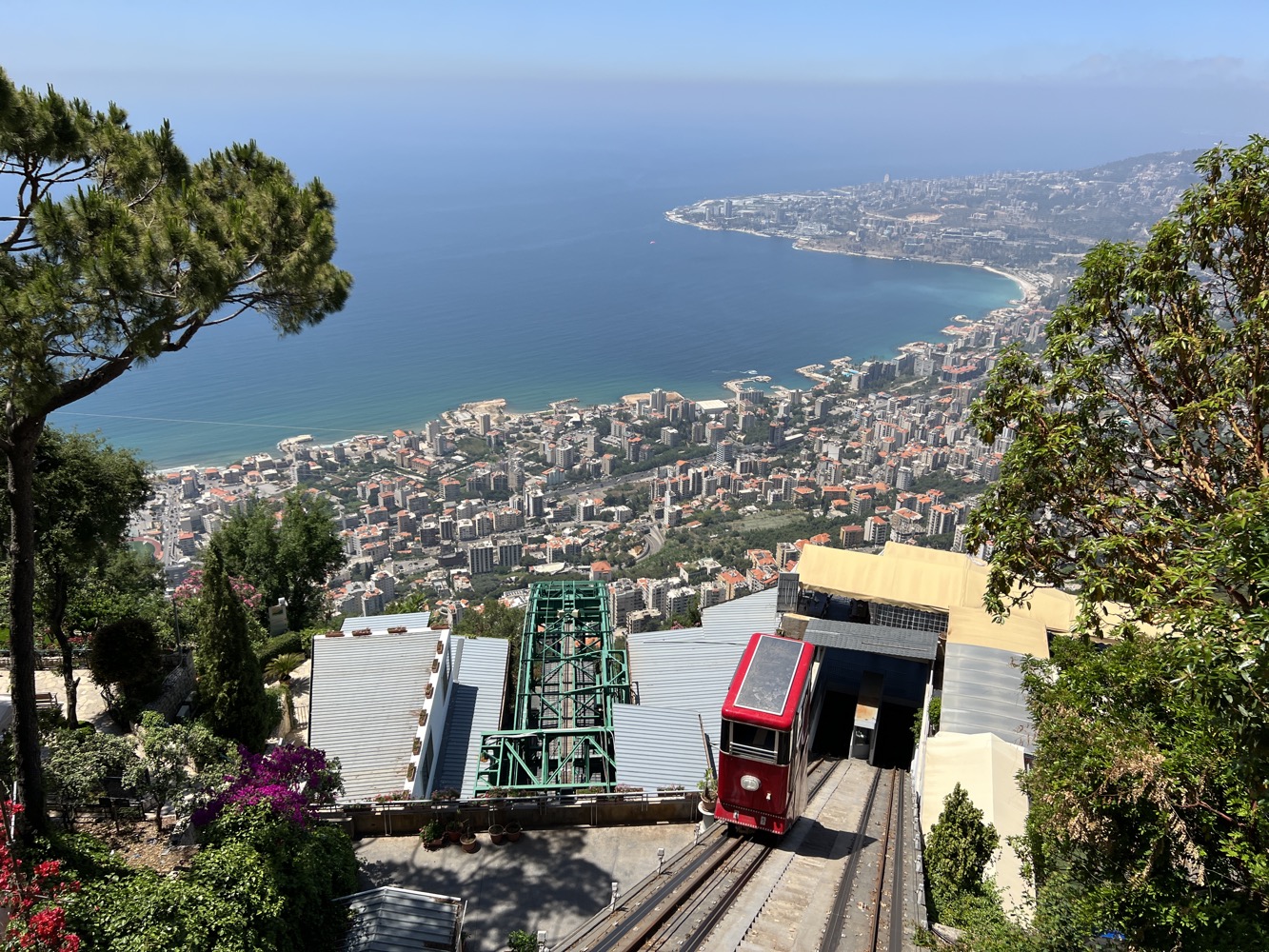 a train going down a hill above a city
