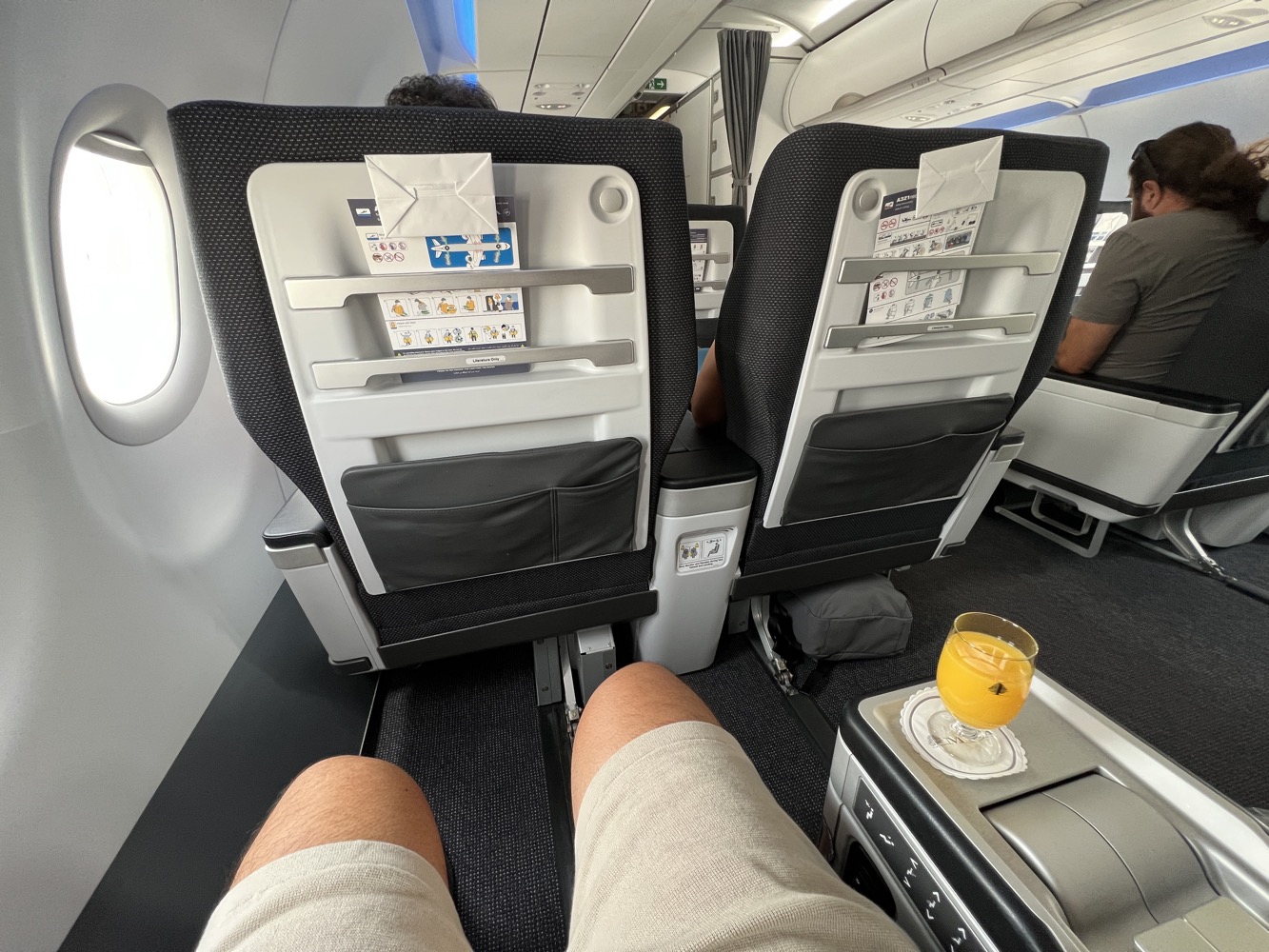 a person's legs in a chair on an airplane