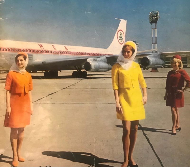 a group of women standing in front of an airplane