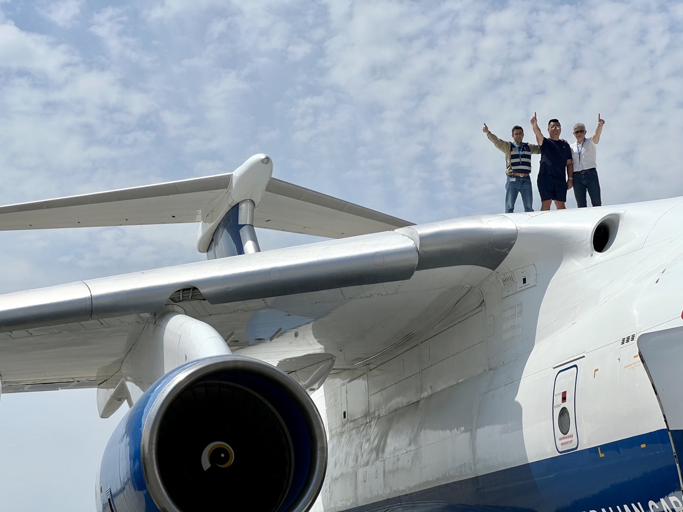 a group of people standing on the wing of a plane