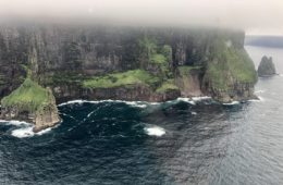 a cliff with water and grass