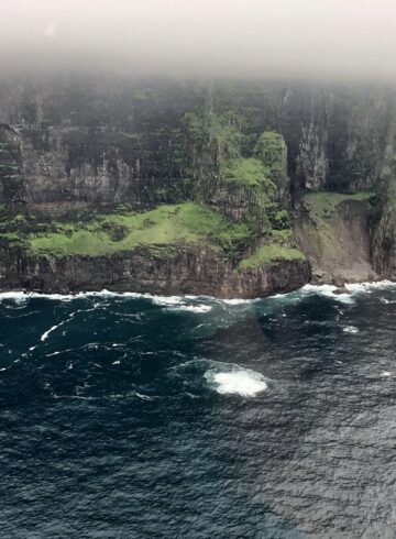 a cliff with water and grass