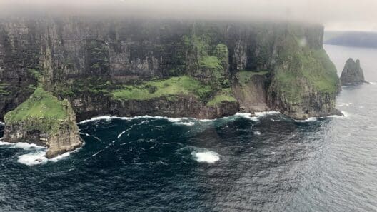 a cliff with water and grass