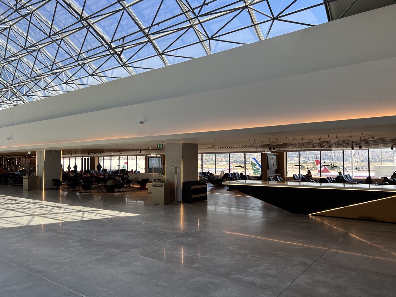an airport lounge with a large glass ceiling