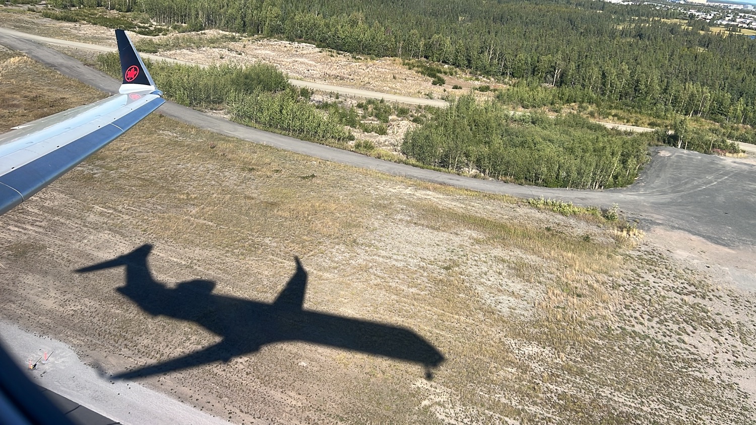 an shadow of an airplane on a dirt road