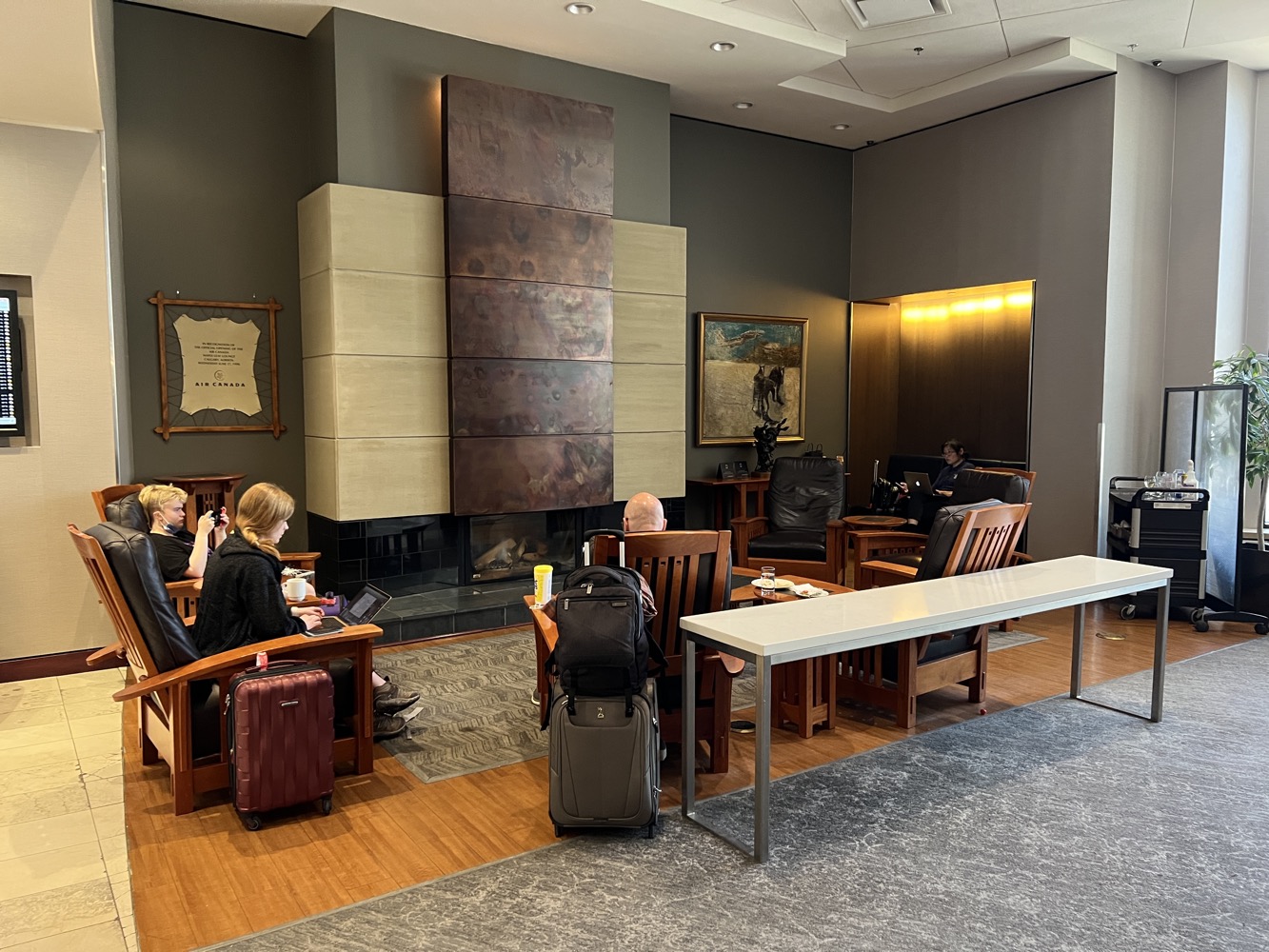 a group of people sitting in a room with luggage