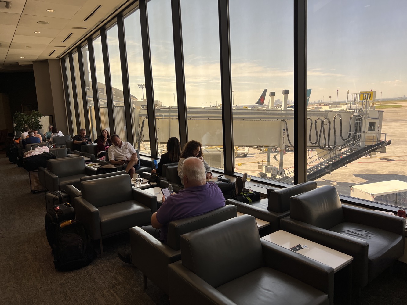 people sitting in a lounge area with large windows