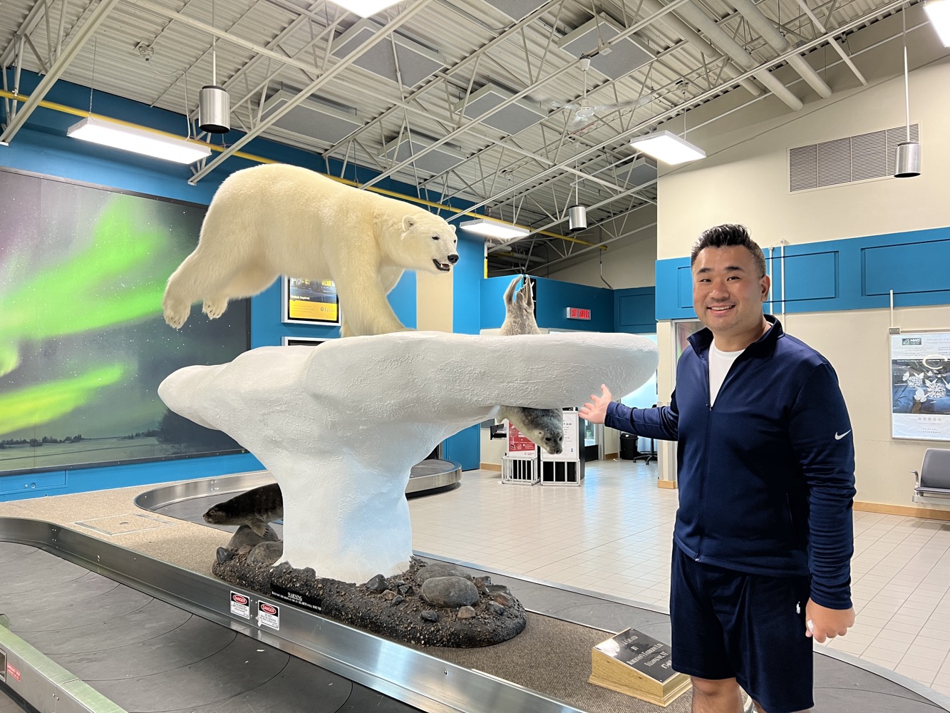 a man standing next to a polar bear sculpture