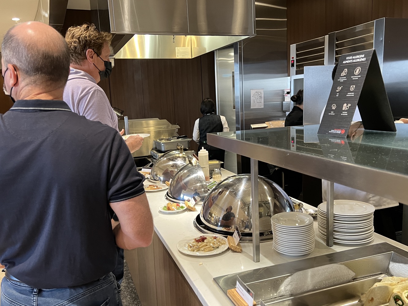 a group of people standing in a kitchen