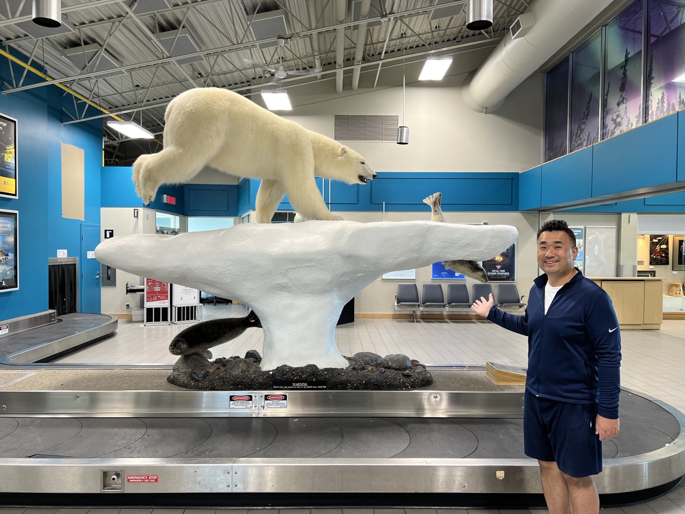 a man standing next to a statue of a polar bear