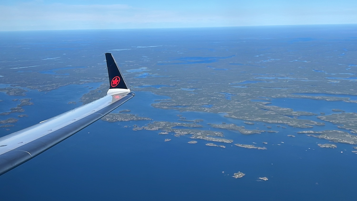 an airplane wing with a red logo above the water