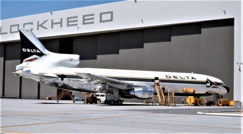 a large airplane parked in front of a hangar