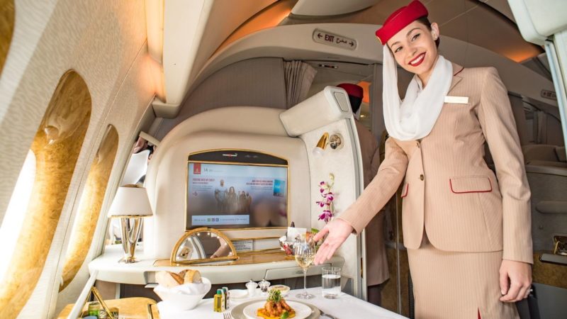 a woman in a suit serving food in a plane