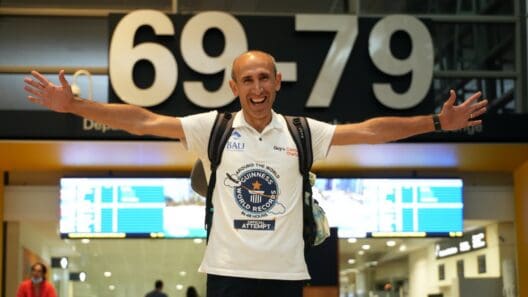 a man with his arms outstretched in front of a sign