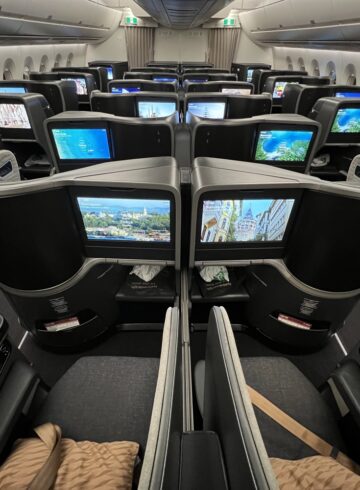 a row of seats with monitors on the side