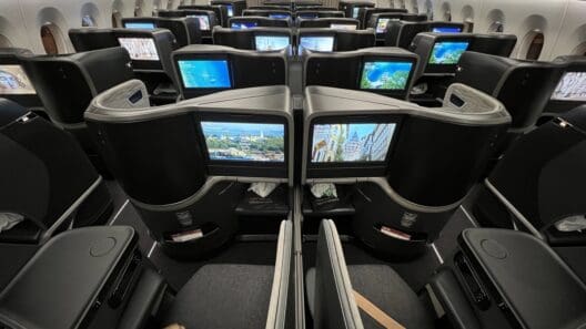 a row of seats with monitors on the side