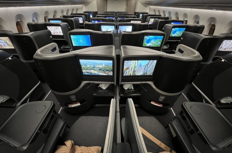 a row of seats with monitors on the side