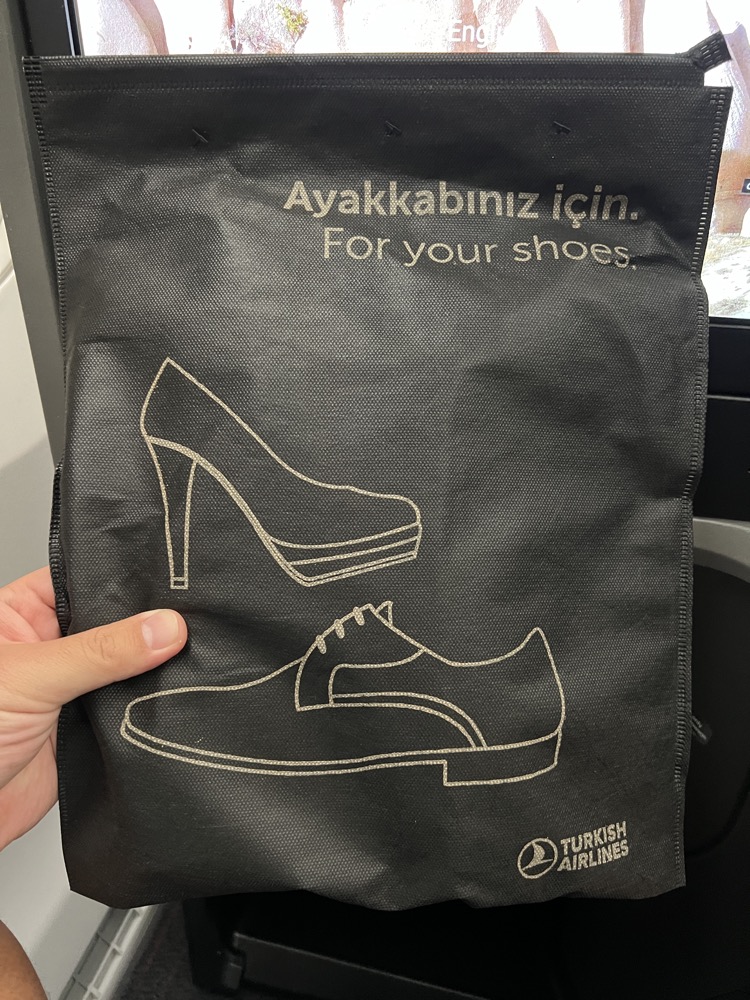 a hand holding a bag with a picture of shoes