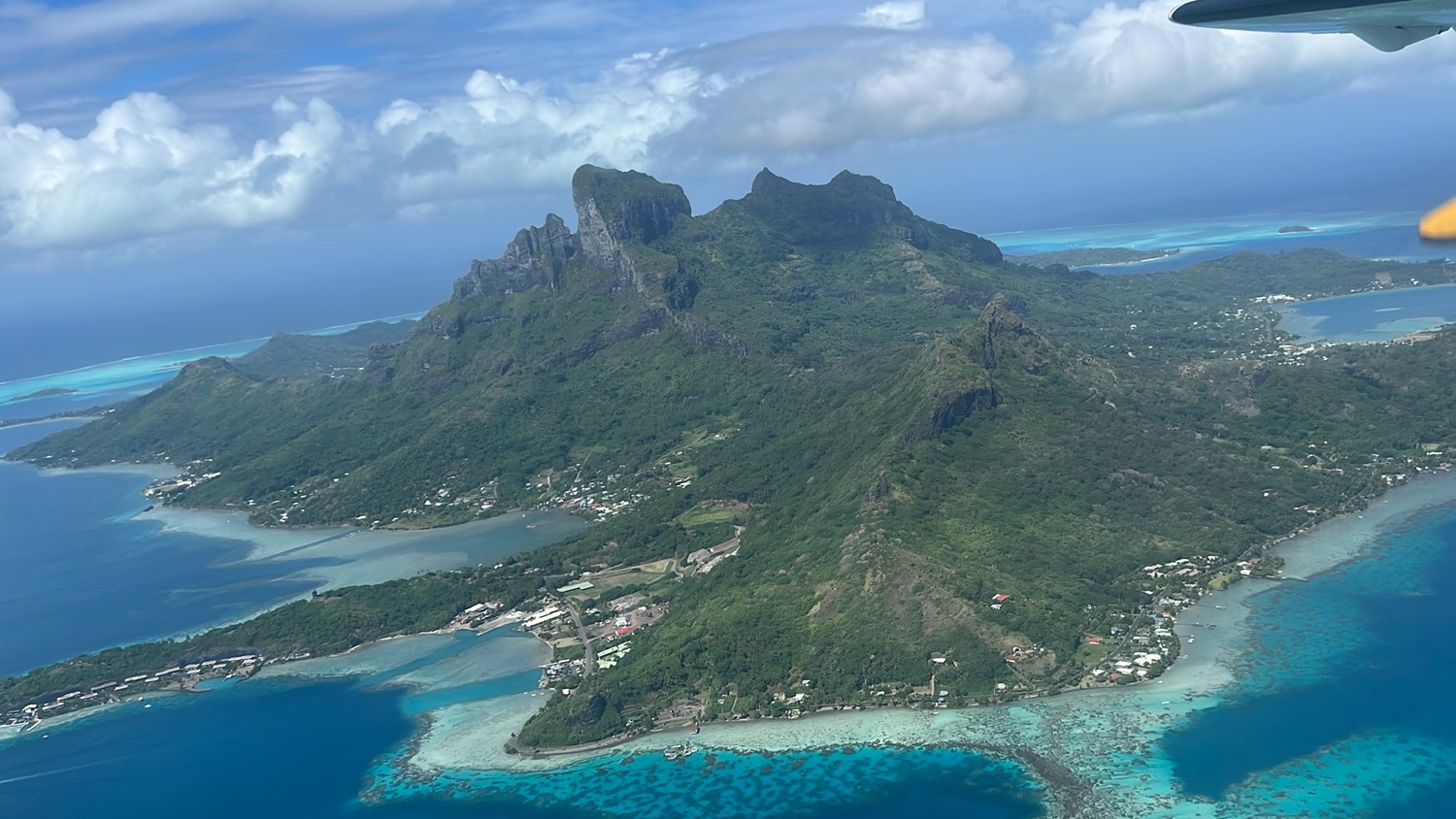 a aerial view of a mountain and blue water