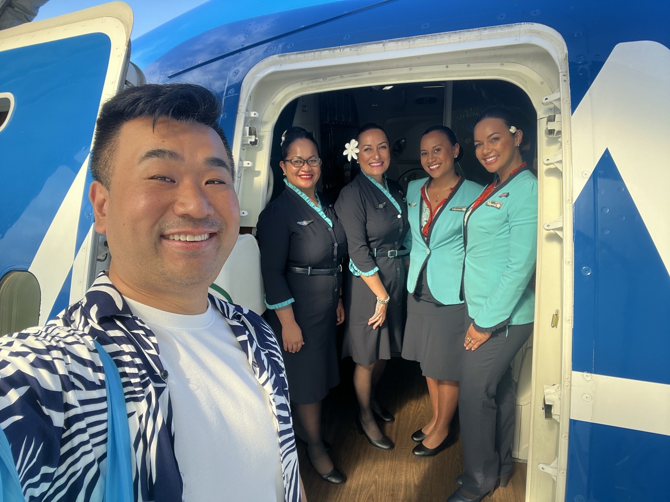 a man taking a selfie with a group of people in the back of a plane