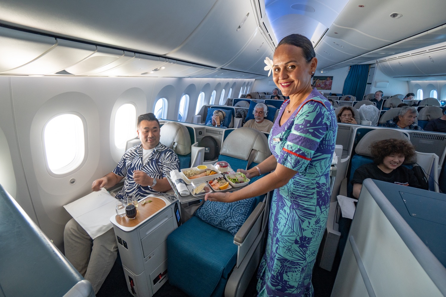 a woman holding a tray of food in a plane