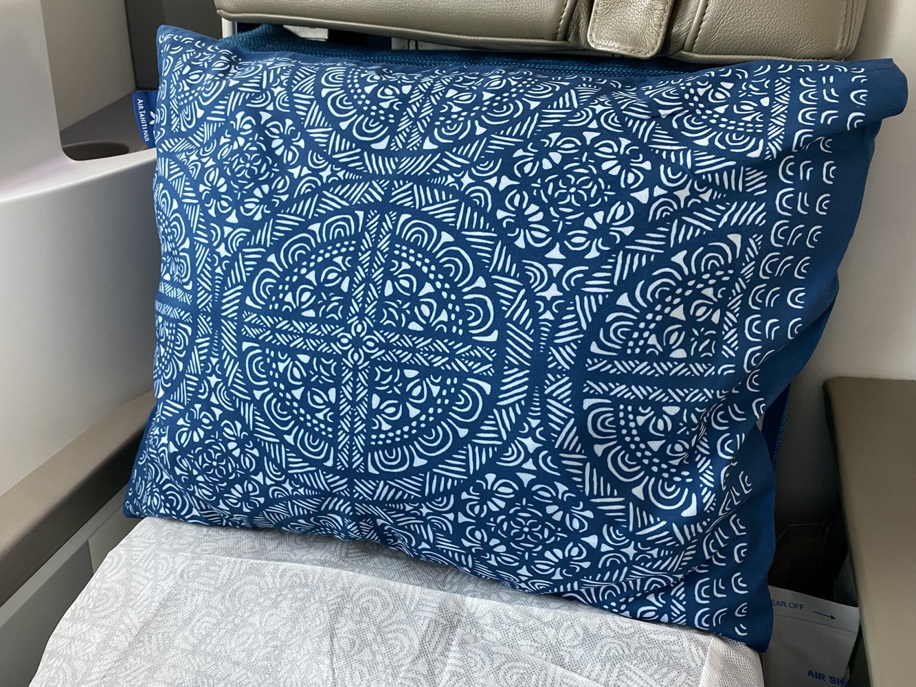 a blue and white pillow on a chair