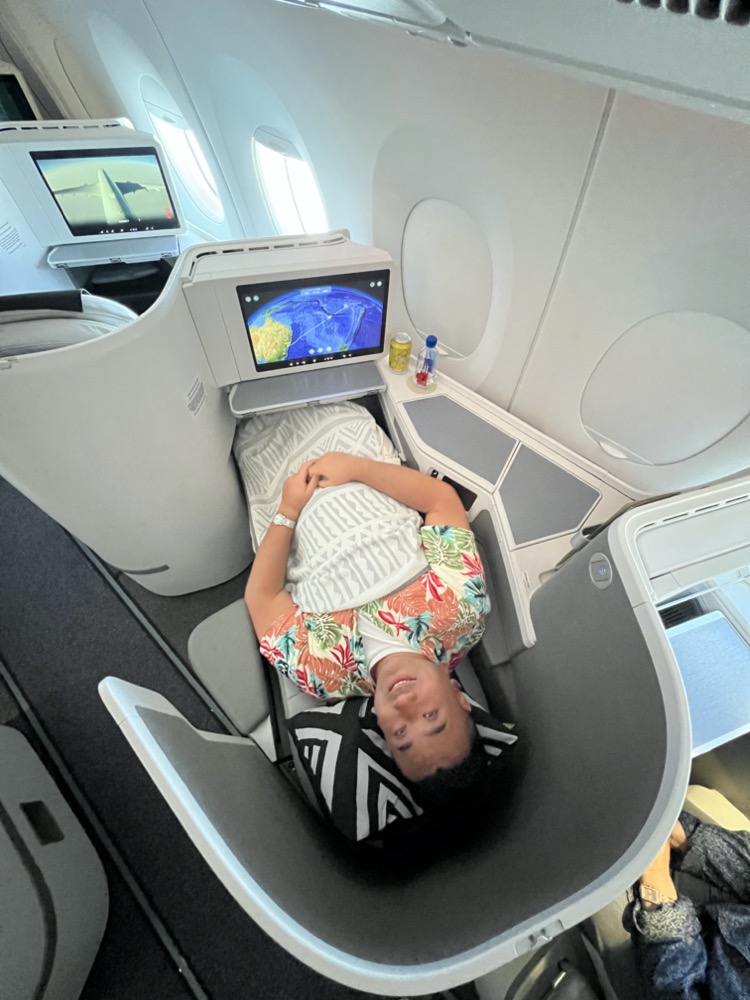 a man lying in a chair in an airplane