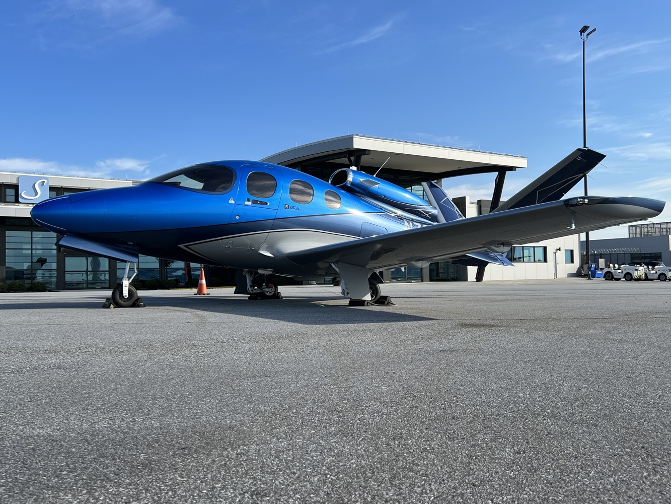 a blue airplane parked in a parking lot