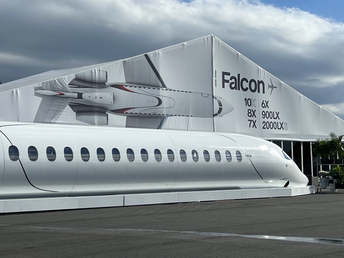 a white airplane next to a large white tent