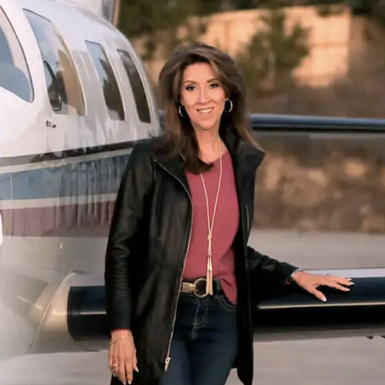 a woman standing next to a plane