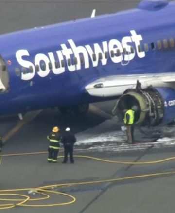 a blue airplane with white text and yellow fire trucks